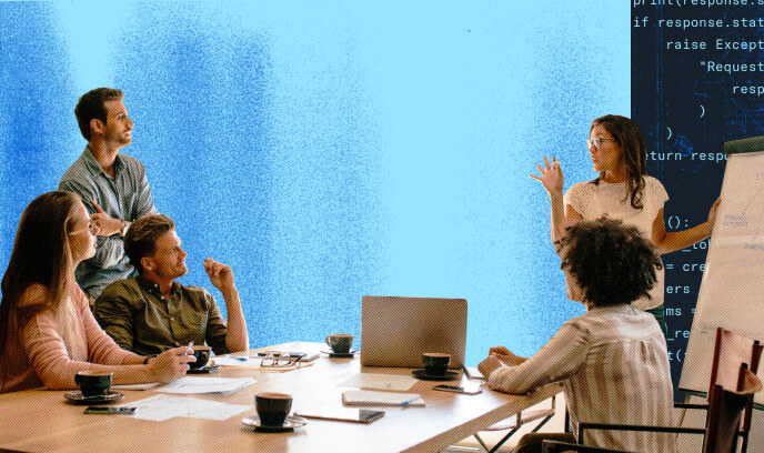 Five business professionals gathered around a large computer monitor with code in the background